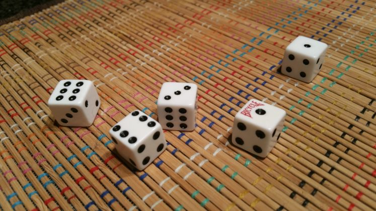 people play dice games around a table